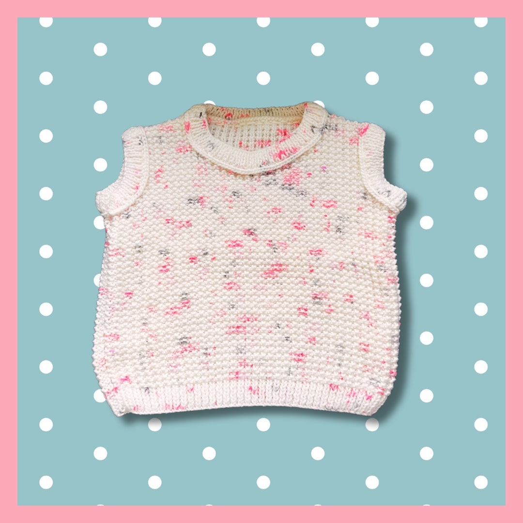White sleeveless sweater with pink dots